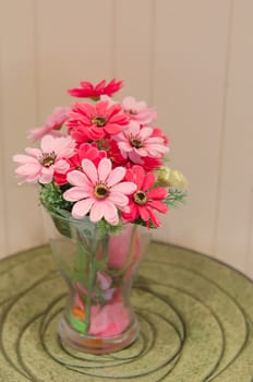 plastic flowers in red vase on  table
