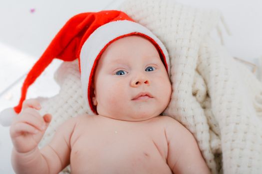 Christmas theme. Portrait of baby boy in a Santa hat in studio