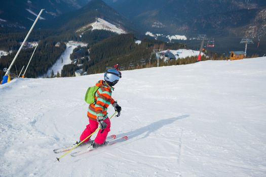 Girl on skis in soft snow on a sunny day in the mountains