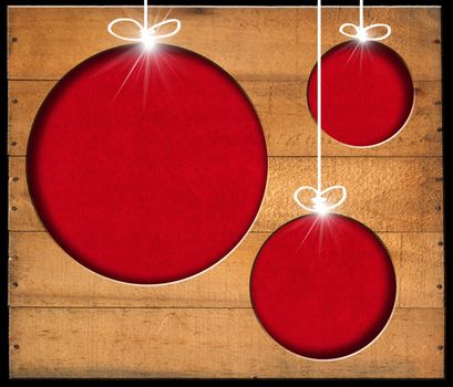 Brown wooden wall with a hole in the shape of Christmas balls with red velvet background