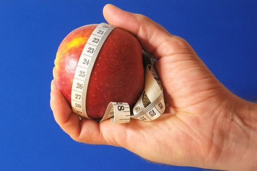 Diet Apple and Meter on the Hand on a Colored Background 