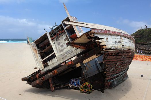 BONDI BEACH, AUSTRALIA - OCTOBER 29, 2013: Sculpture By The Sea, Bondi. Annual event showcases artists around the world  Sculpture titled 'Washed Up' by Tunni Kraus (VIC).  Medium fishing trawler, found materials