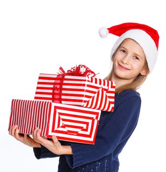 Christmas theme - Smiling cute girl in Santa's hat with gift box, isolated on white