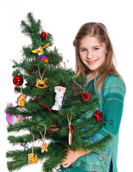 Christmas theme - Beautiful girl decorating christmas tree. Isolated on white backround.