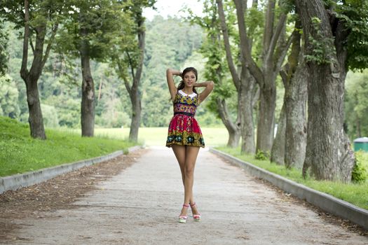 Full growth, beautiful young woman in color dress