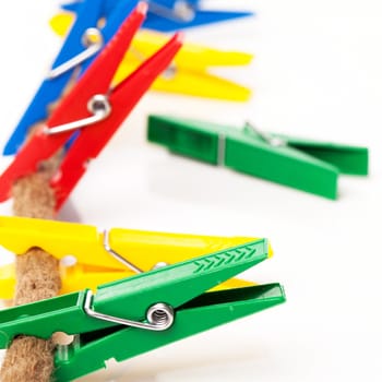 Closeup image of colorful clothespins with cord on a white background