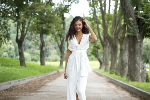 Happy woman in a white dress on the street
