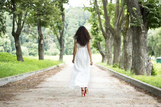 Full growth, beautiful young woman in white dress