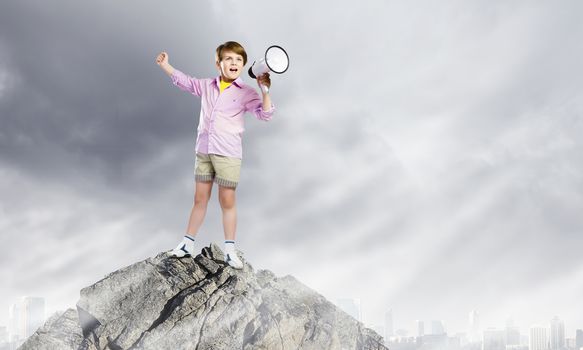 Image of little cute boy shouting in megaphone