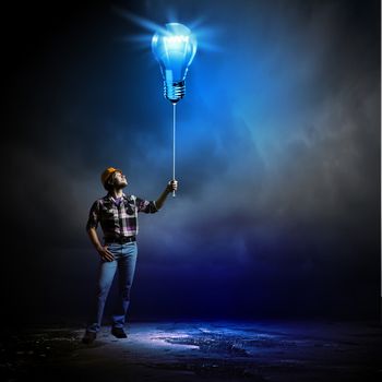 Image of man builder holding electrical bulb