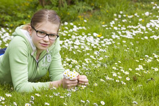 young girl picking daisies