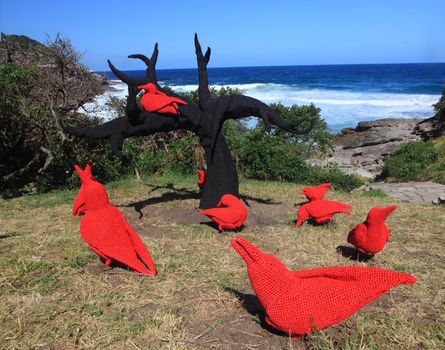 BONDI BEACH, AUSTRALIA - OCTOBER 30, 2013: Sculpture By The Sea, Bondi. Annual event showcases artists around the world  Sculpture titled 'East of the mulberry tree, the legend of the ten red crows' by Mikaela Castledine (WA).  Medium crocheted polypropylene, steel