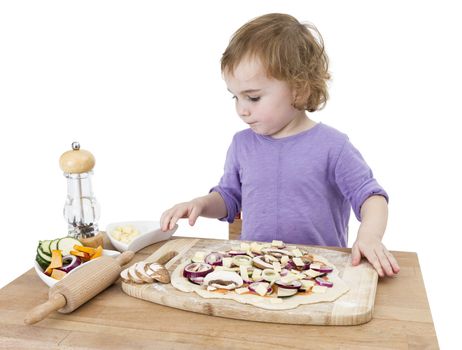 preschooler making fresh pizza on wooden desk. isolated on white background