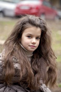 Autumn portrait of a beautiful young girl on the street