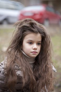 Autumn portrait of a beautiful young girl on the street