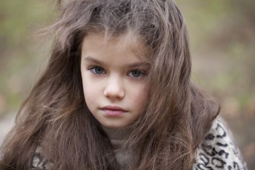 Autumn portrait of a beautiful young girl on the street