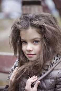 Autumn portrait of a beautiful young girl on the street