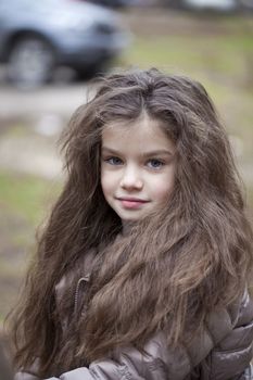 Autumn portrait of a beautiful young girl on the street