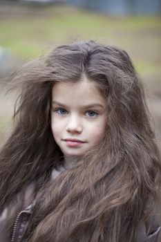 Autumn portrait of a beautiful young girl on the street