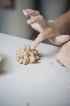 Girl make toy from clay. High resolution image.