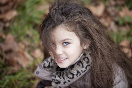Autumn portrait of a beautiful young girl on the street