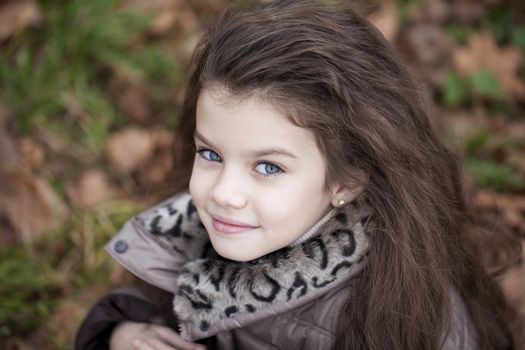 Autumn portrait of a beautiful young girl on the street