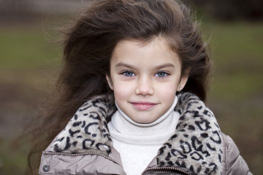 Autumn portrait of a beautiful young girl on the street