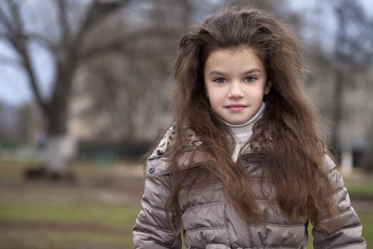 Autumn portrait of a beautiful young girl on the street