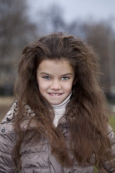 Autumn portrait of a beautiful young girl on the street