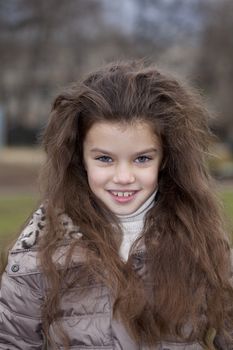Autumn portrait of a beautiful young girl on the street