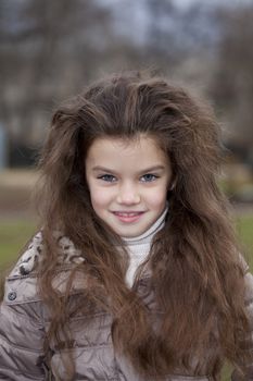 Autumn portrait of a beautiful young girl on the street