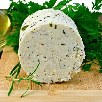 Homemade cheese with herbs and spices, parsley, rosemary, vegetable oil in a bottle on a wooden board