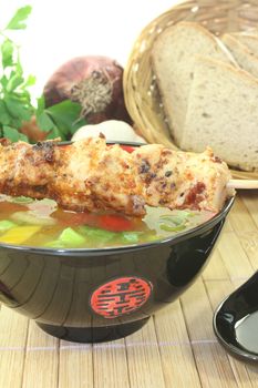 Chicken consomme in a bowl on a light background