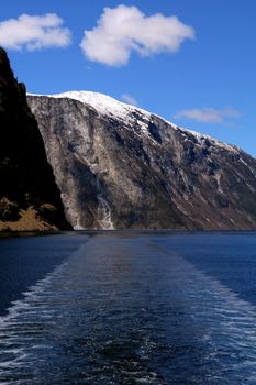 Gudvangen fjord landscape, mountain in the backgroung and boat trail,  Norway