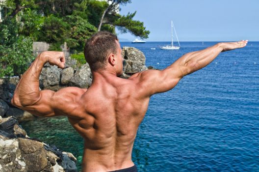 Muscular young bodybuilder outdoors 