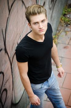 Attractive blond young man in city environment, shot from above