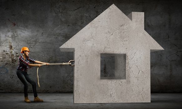 Image of woman in hardhat pulling model of house