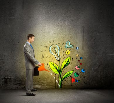 Image of businessman watering sprout with can