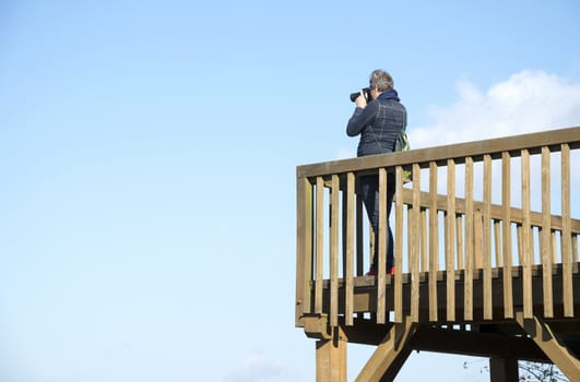 aldult woman making photos from observation post