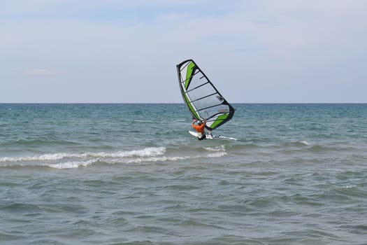 The man is engaged in windsurfing in the sea.