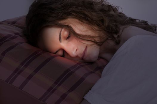 Young woman sleeping on a red pillow