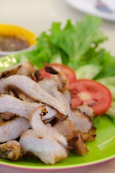 close up sliced roasted  pork  served with tomato and lettuce  and chili sauce