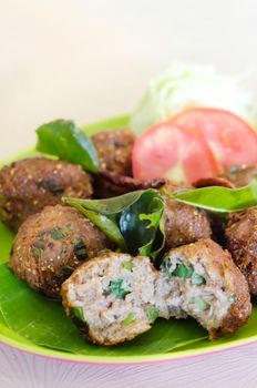 close up meatballs served with fried  bergamot leaves and fresh vegetable