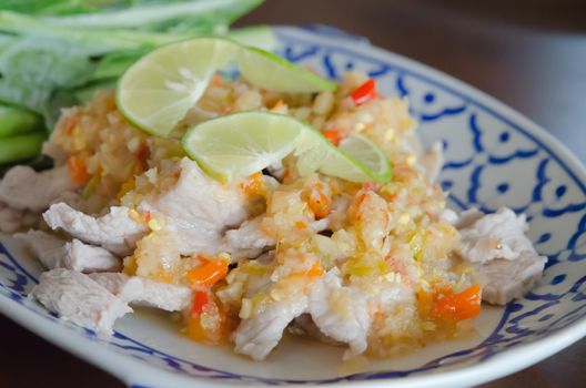 close up spicy pork served with chili sauce ,  fresh lime on top