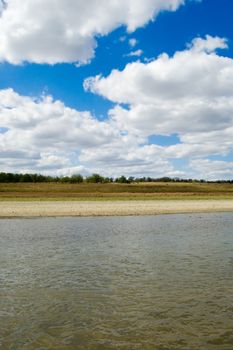 white clouds above beautiful bent steppe river