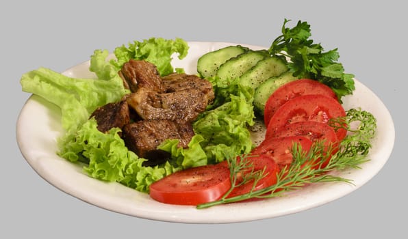 Stew with vegetables on the white plate. Isolated on the gray background.