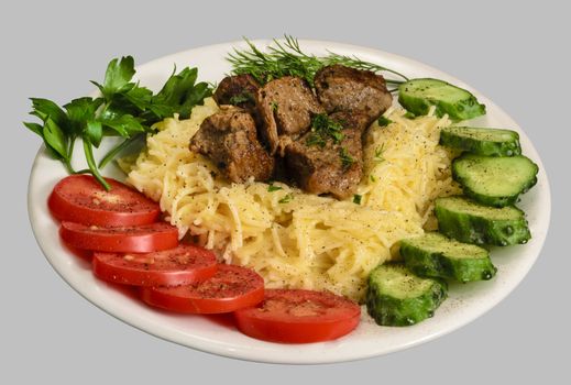 Vermicelli with stew meat and vegetables on the white plate. Isolated on the gray background.