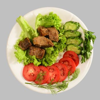 Stew with vegetables on the white plate. Isolated on the gray background.