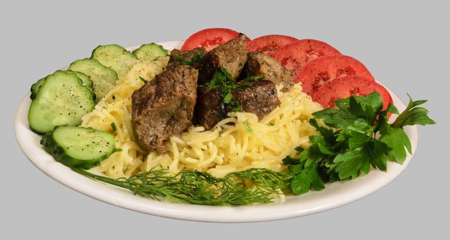 Vermicelli with stew meat and vegetables on the white plate. Isolated on the gray background.