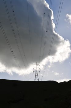 Electricity pylon on the South Downs,Sussex,England.Nature versus man as a large storm cloud hangs above the man made structure.